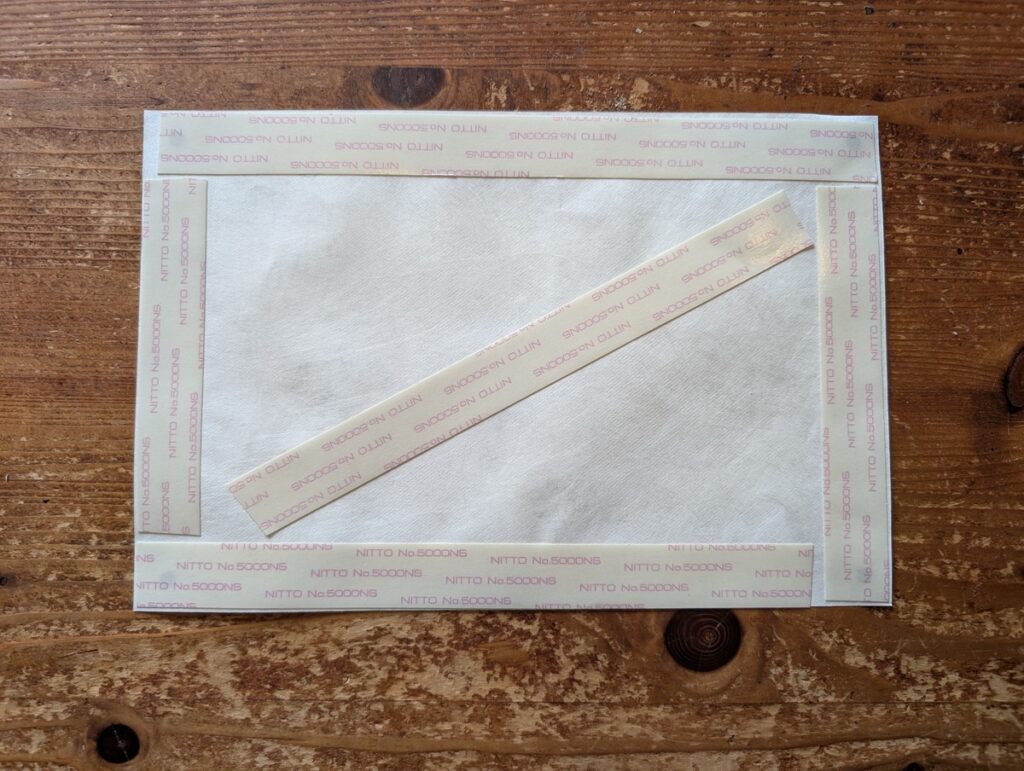 ゼッケン裏の四辺＋斜めにテープを貼る